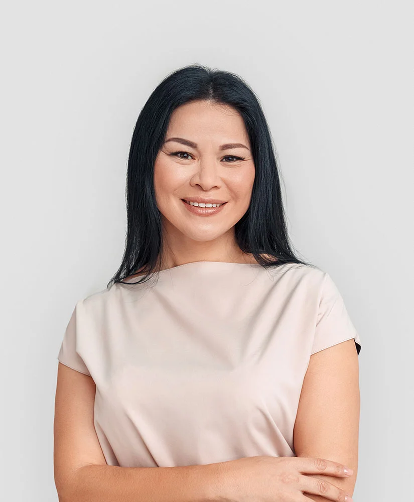 Asian woman posing with arms folded and smiling